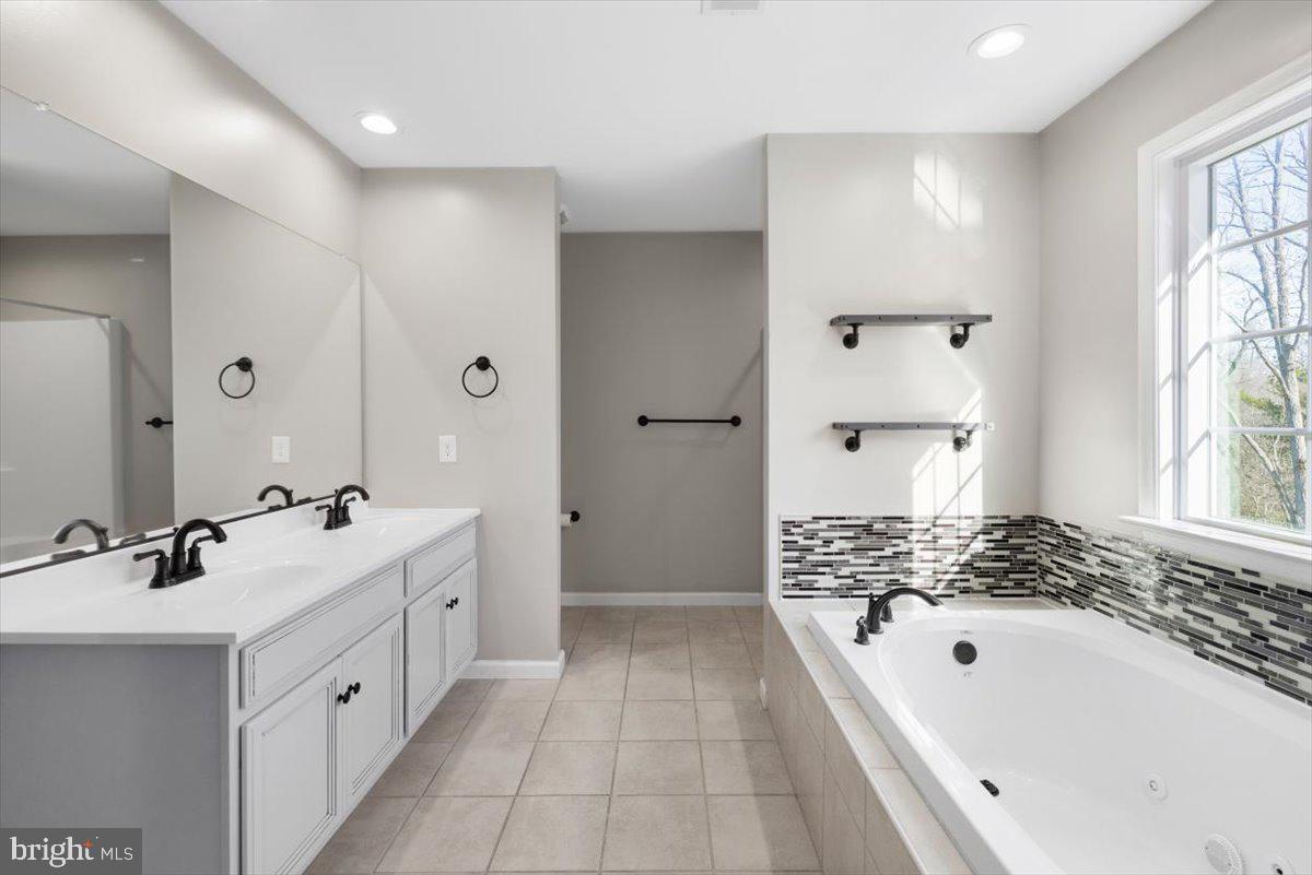 441 Shady Creek Road Clear Brook, VA 22624 - Photo 29 of 46 a large white bathroom with a double vanity sink a mirror a bathtub and shower