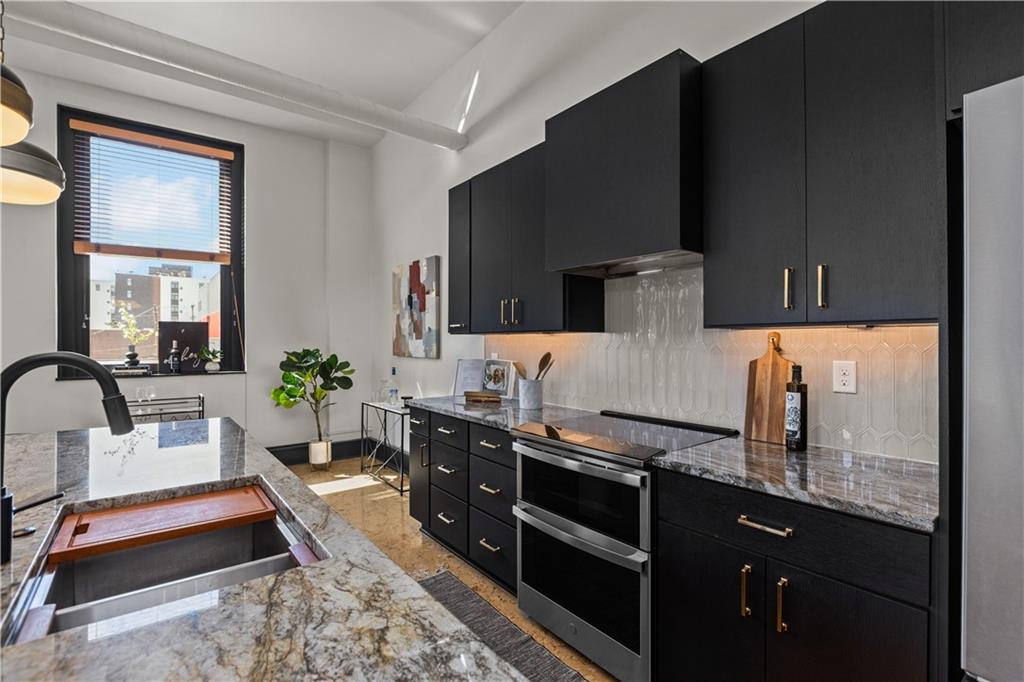 3080 Smallman Street, Unit 8 Pittsburgh, PA 15201 - Photo 15 of 39 a kitchen with granite countertop a sink dishwasher stove and cabinets