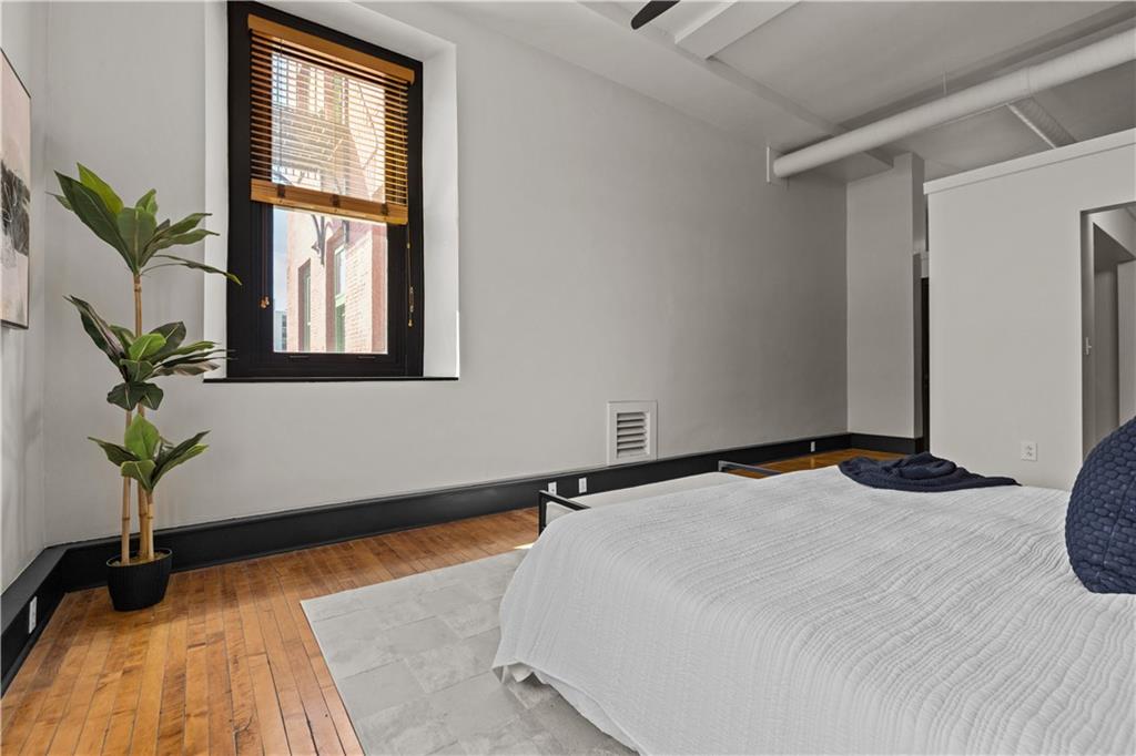 3080 Smallman Street, Unit 8 Pittsburgh, PA 15201 - Photo 26 of 39 a bedroom with a bed and wooden floor