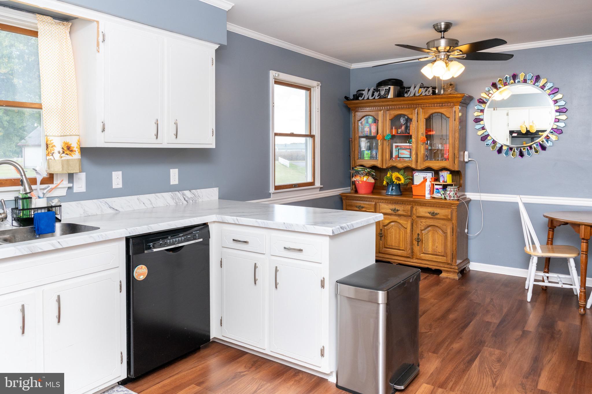 22400 Zoar Road Georgetown, DE 19947 - Photo 19 of 32 a kitchen with stainless steel appliances granite countertop a stove a sink dishwasher and white cabinets with wooden floor