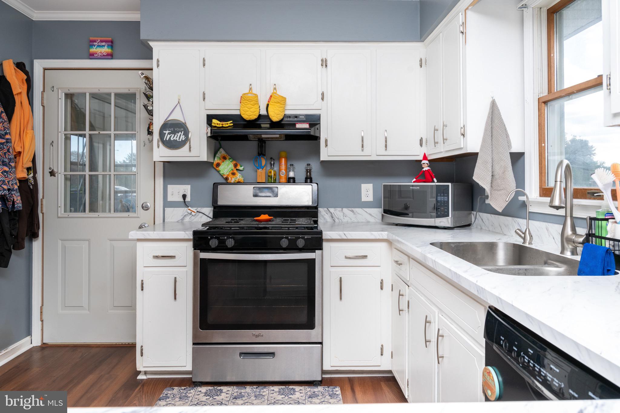 22400 Zoar Road Georgetown, DE 19947 - Photo 21 of 32 a kitchen with stainless steel appliances granite countertop a stove a sink and a microwave