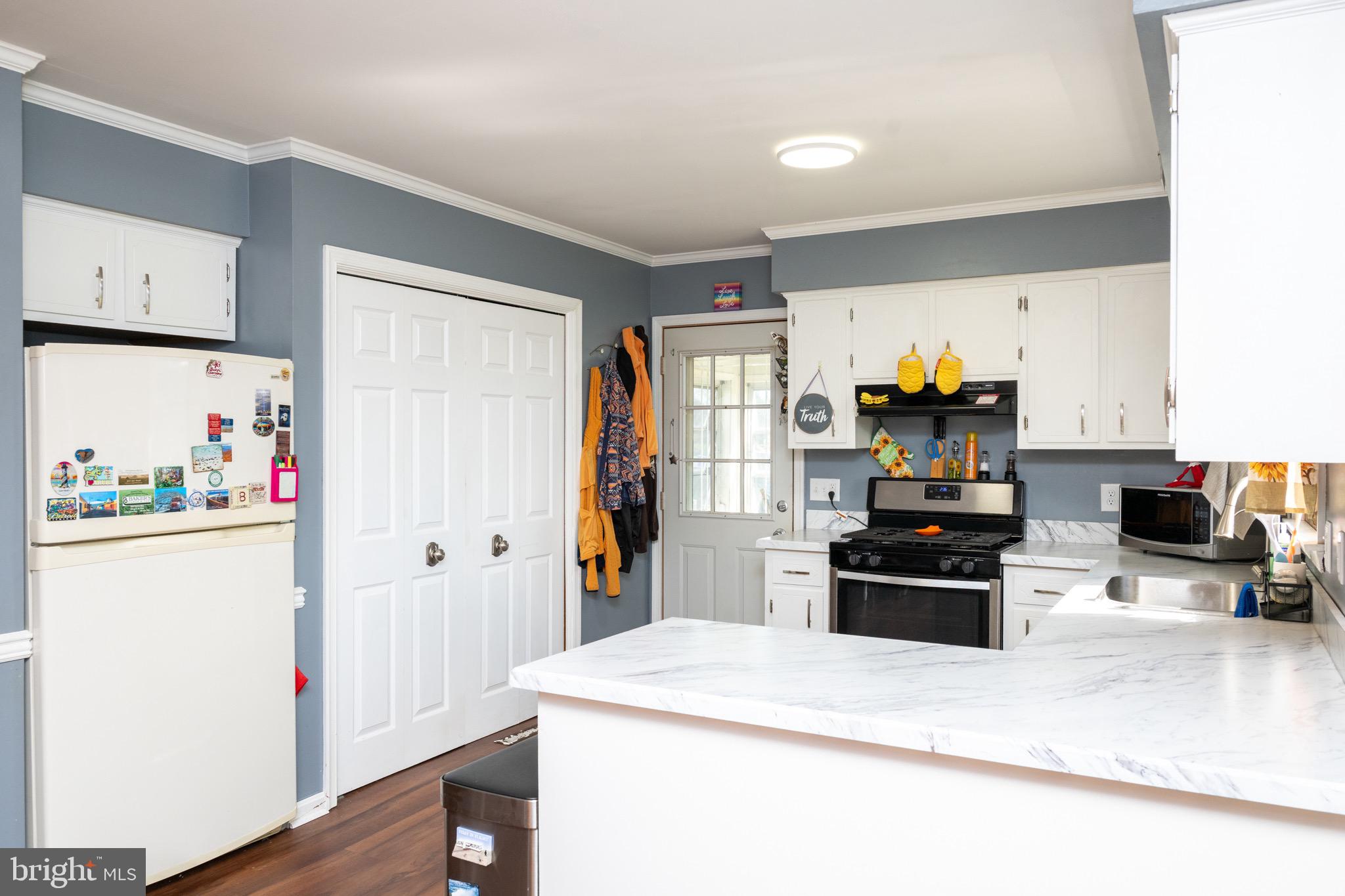 22400 Zoar Road Georgetown, DE 19947 - Photo 24 of 32 a kitchen with a refrigerator and a stove top oven