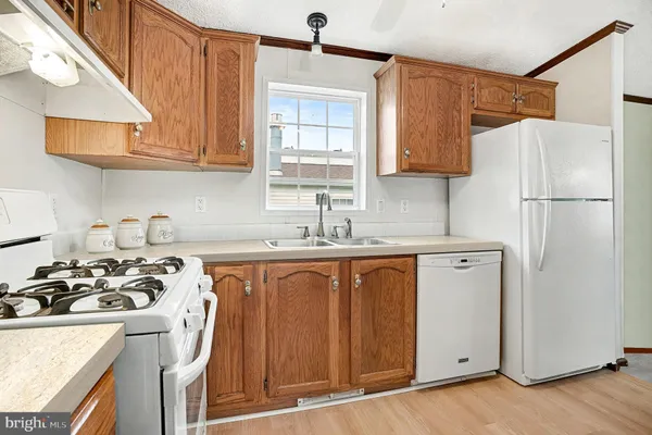 a kitchen with stainless steel appliances granite countertop a refrigerator a sink dishwasher a stove with wooden cabinets and floor