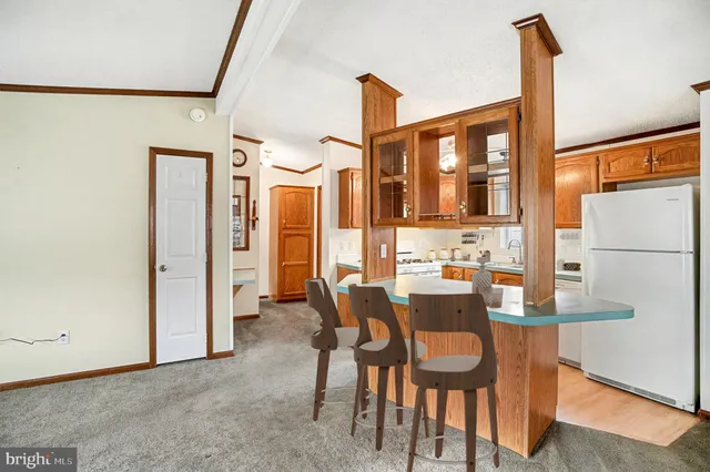 a view of kitchen with granite countertop cabinets and refrigerator