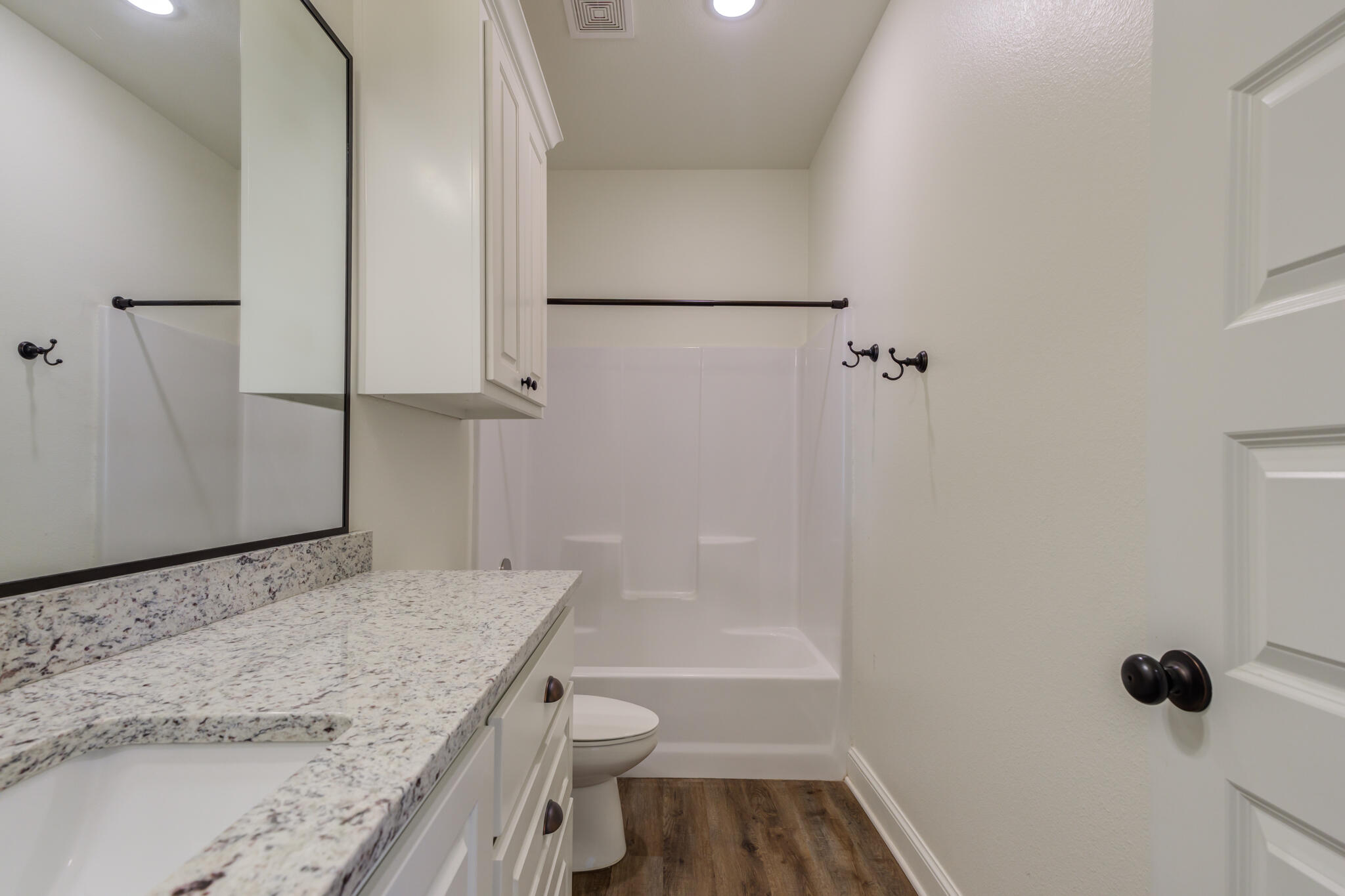 6908 55th Street Lubbock, TX 79407 - Photo 12 of 42 a bathroom with a granite countertop sink toilet and shower