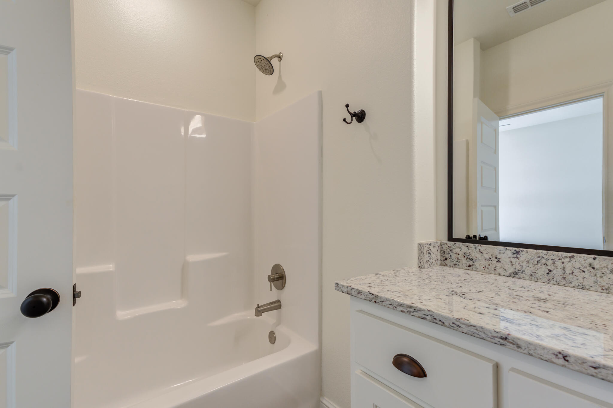 6908 55th Street Lubbock, TX 79407 - Photo 18 of 42 a bathroom with a granite countertop sink and a mirror