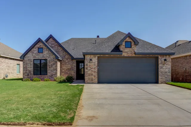 a front view of a house with a yard and garage