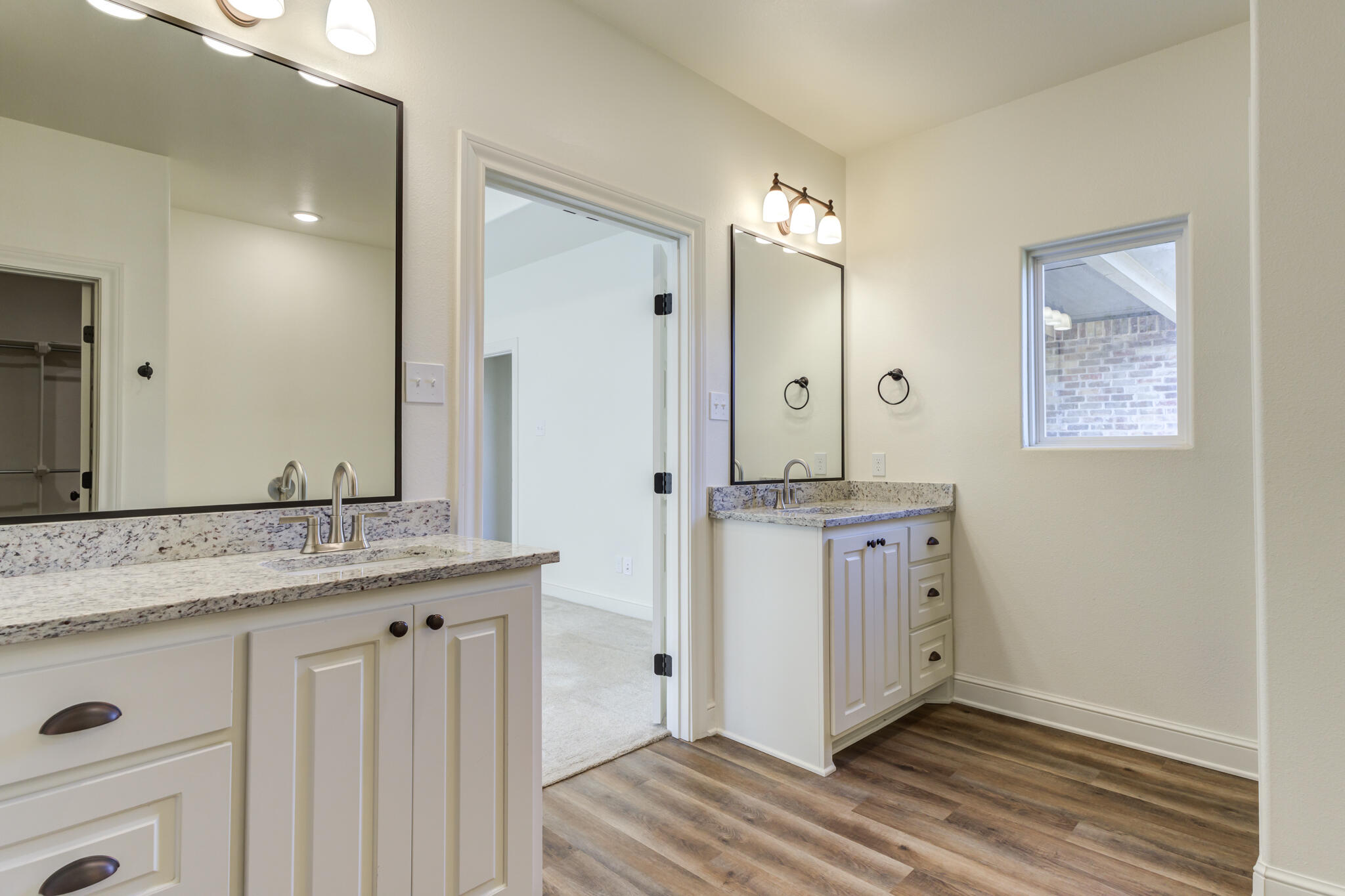 6908 55th Street Lubbock, TX 79407 - Photo 23 of 42 a bathroom with a granite countertop sink a mirror and a shower