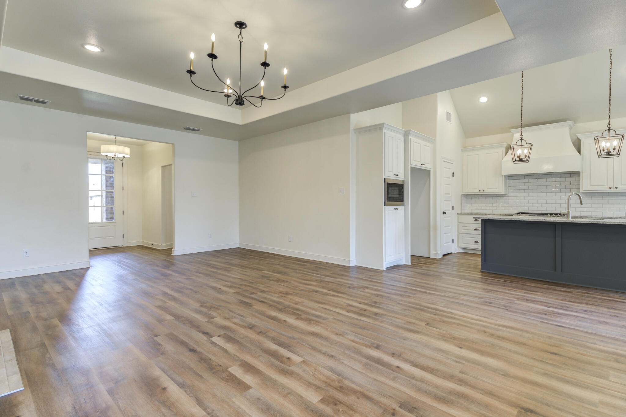 6908 55th Street Lubbock, TX 79407 - Photo 25 of 42 a view of an empty room and kitchen with wooden floor