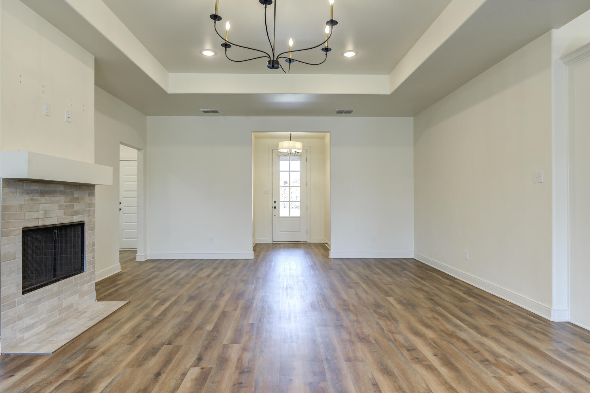 6908 55th Street Lubbock, TX 79407 - Photo 26 of 42 a view of an empty room with wooden floor fireplace and a window