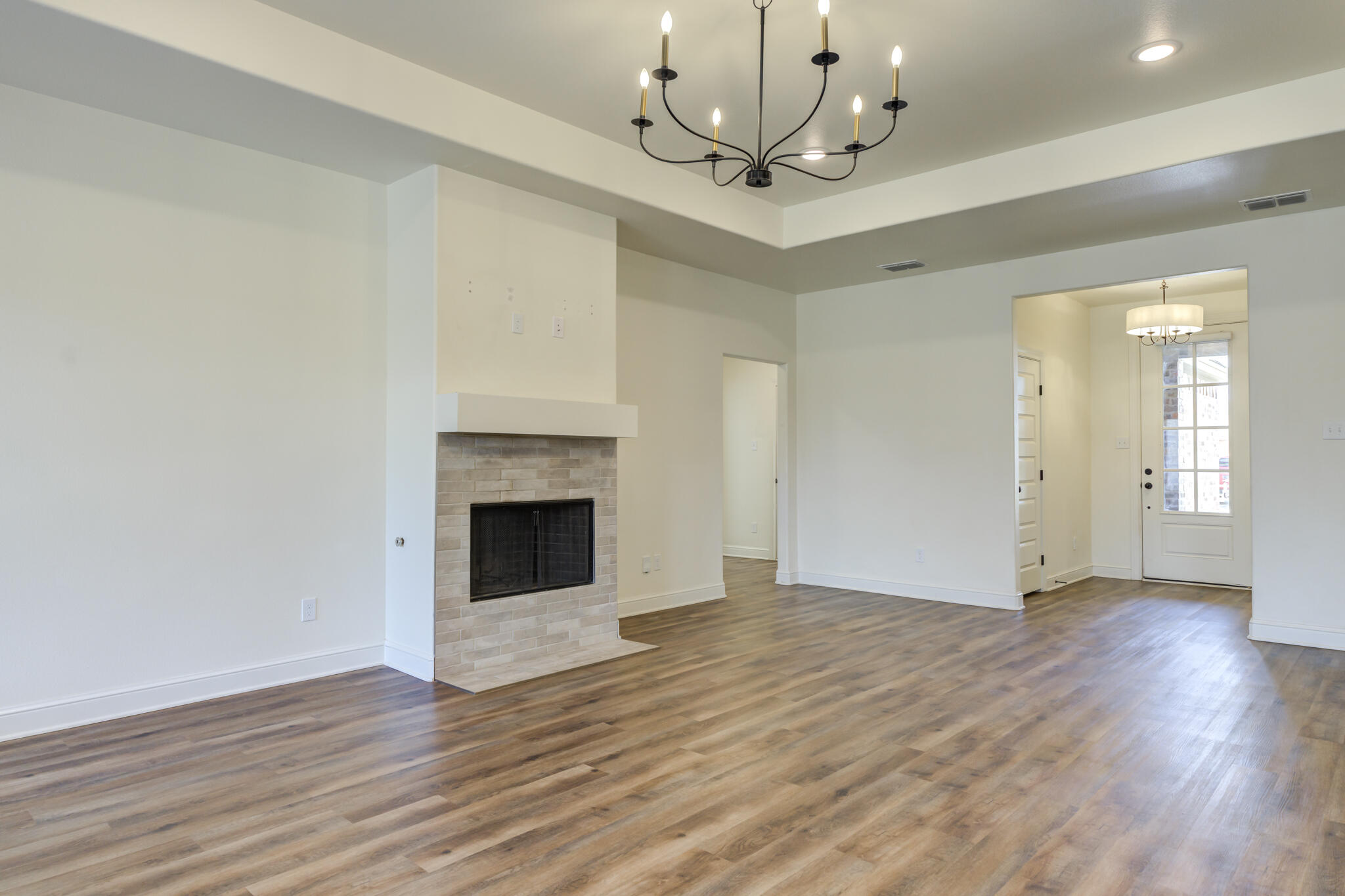 6908 55th Street Lubbock, TX 79407 - Photo 27 of 42 a view of an empty room with wooden floor and a fireplace