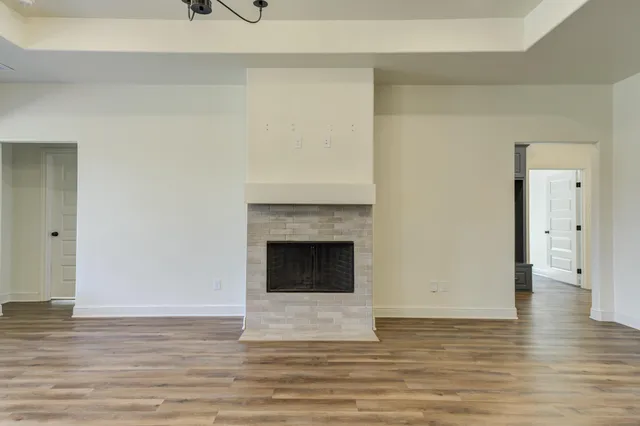 a view of a livingroom with wooden floor and a fireplace