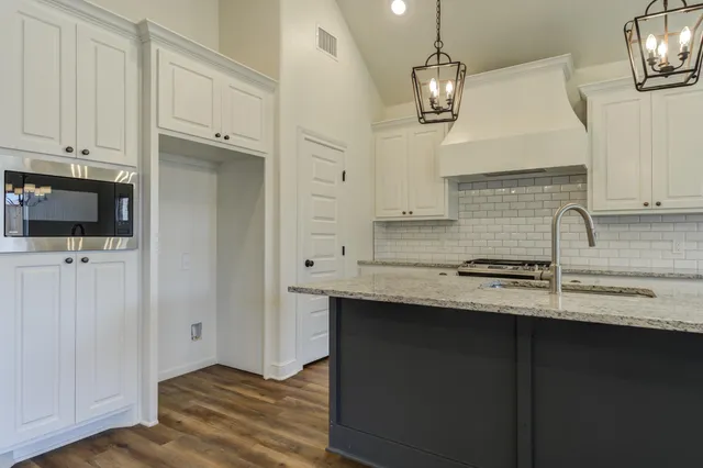 a kitchen with stainless steel appliances granite countertop a sink a stove and a refrigerator