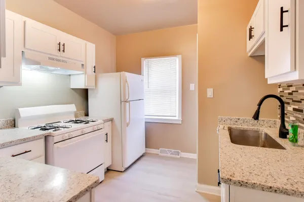 a kitchen with a stove a refrigerator and cabinets