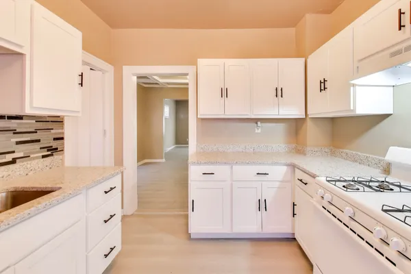 a kitchen with white cabinets and white appliances