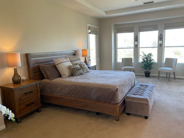 a bedroom with a bed chair and window