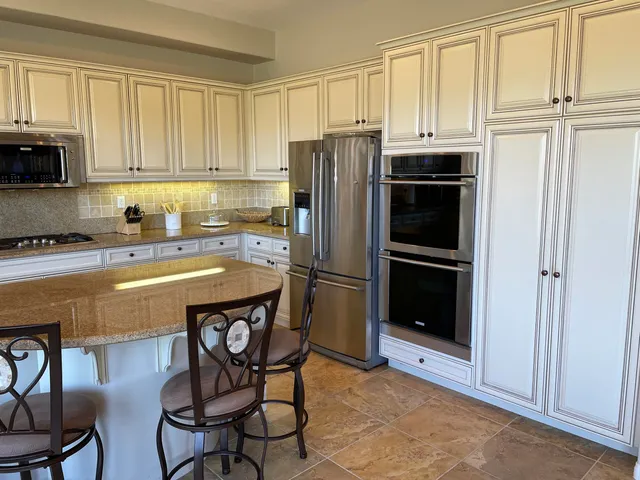 a kitchen with stainless steel appliances a refrigerator sink and cabinets