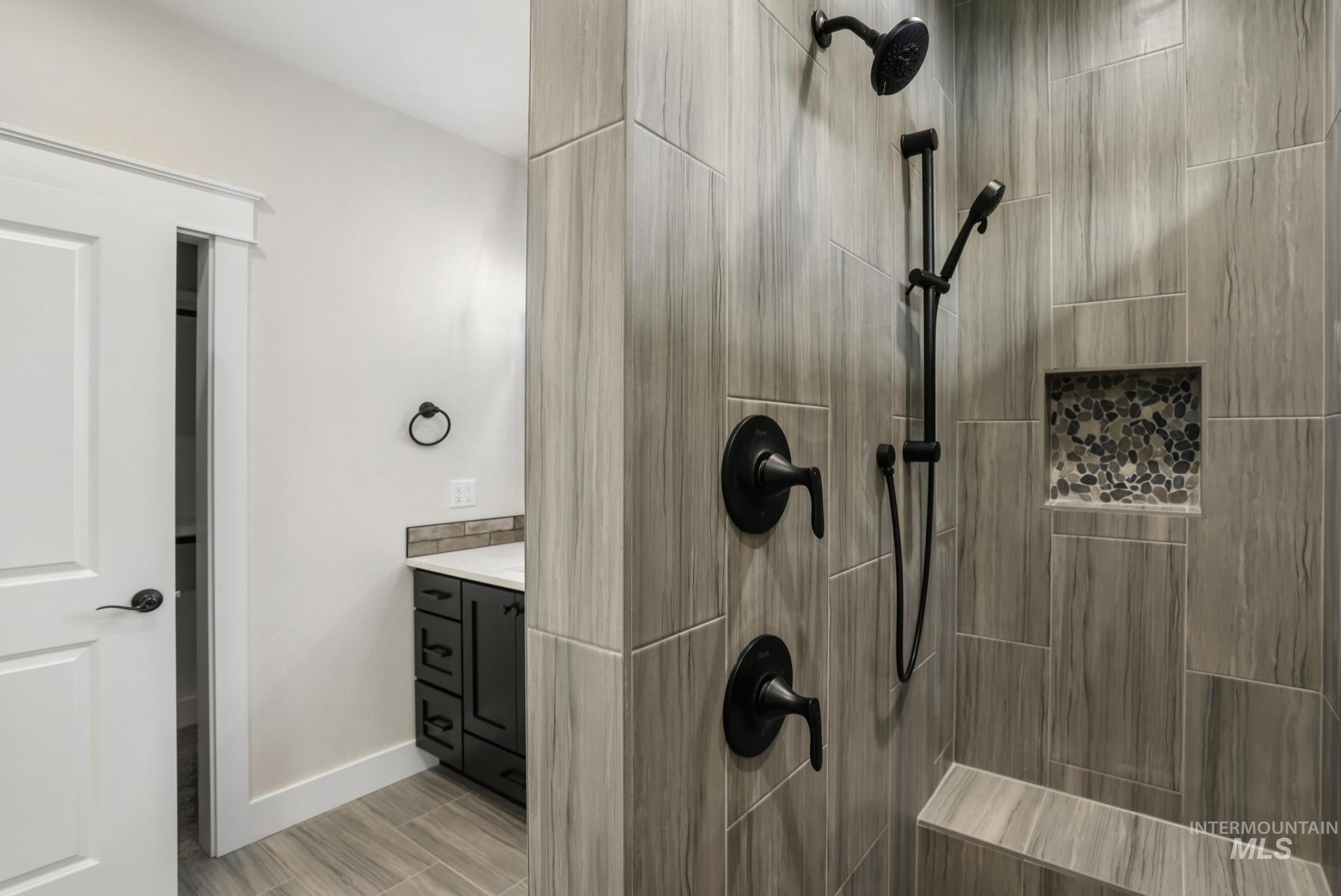1413 Haizlee Way Twin Falls, ID 83301 - Photo 15 of 28 Bathroom with a tile shower, vanity, and wood finish floors