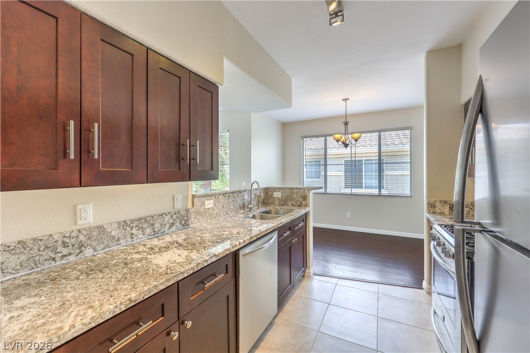 9050 West Warm Springs Road, Unit 2033 Las Vegas, NV 89148 - Photo 9 of 30 A sleek kitchen features rich cabinetry, granite countertops, and modern stainless steel appliances.