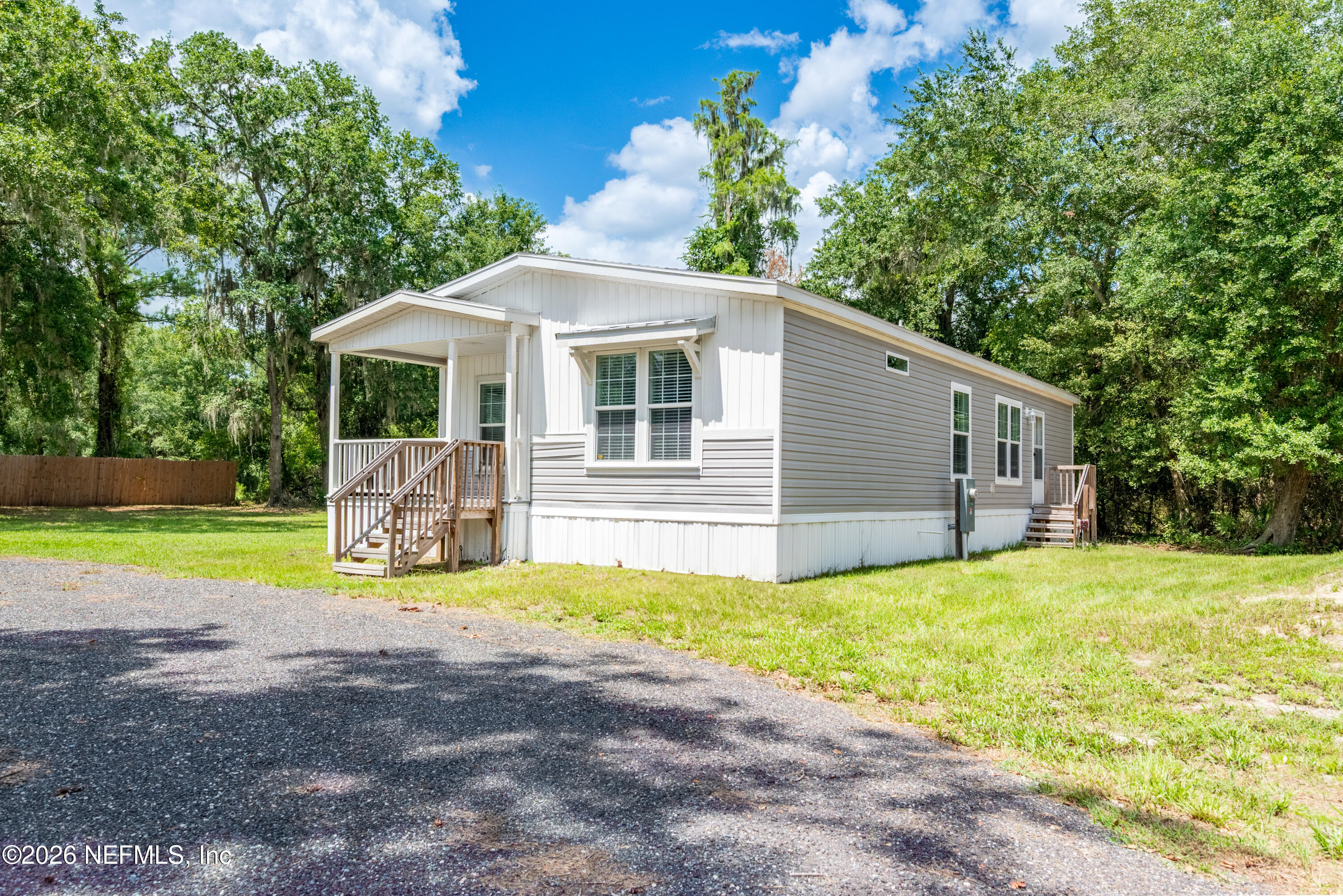 15049 Southwest 75th Avenue Starke, FL 32091 - Photo 14 of 64 a front view of house with yard and trees in the background