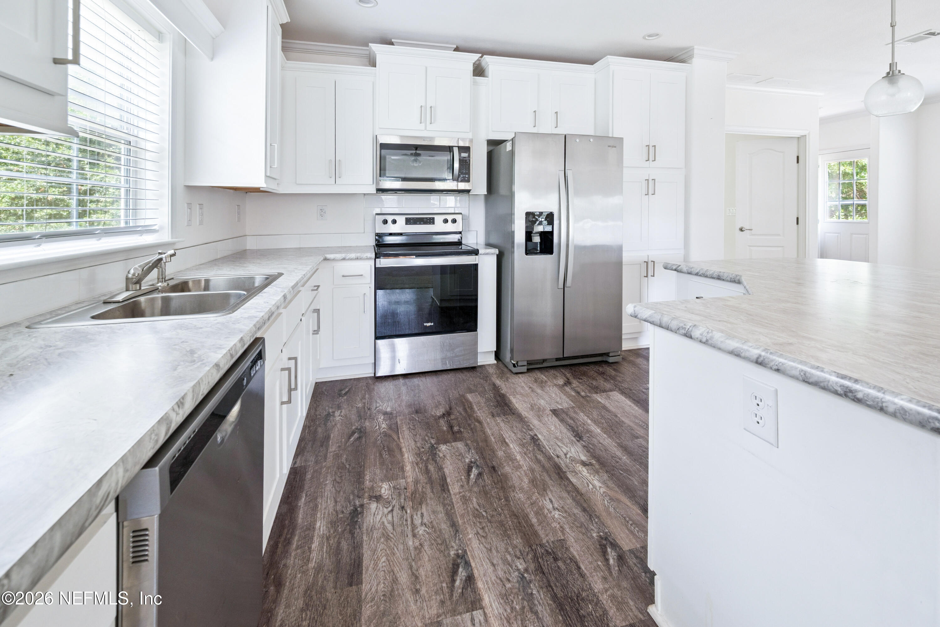 15049 Southwest 75th Avenue Starke, FL 32091 - Photo 2 of 64 a kitchen with stainless steel appliances granite countertop a refrigerator a sink dishwasher a stove and white countertops with wooden floor