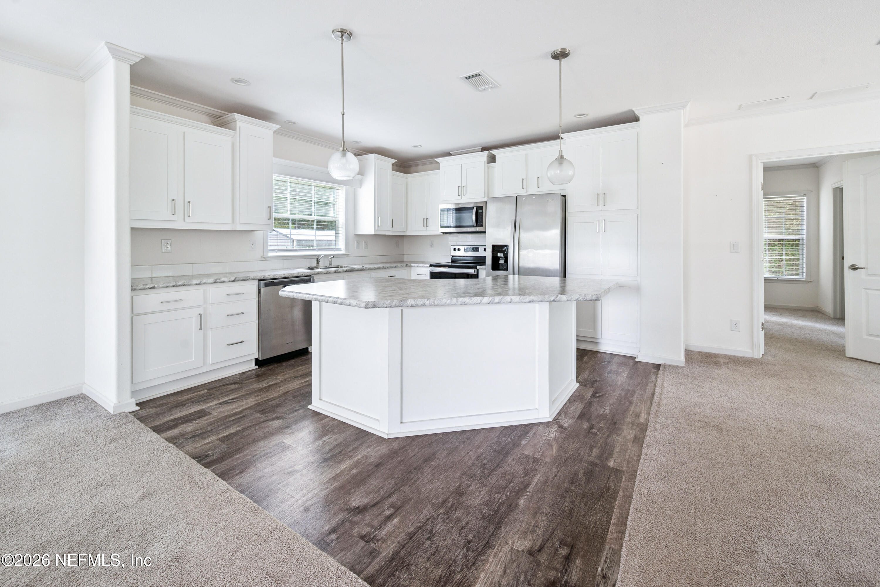 15049 Southwest 75th Avenue Starke, FL 32091 - Photo 43 of 64 a kitchen with kitchen island a sink a stove a refrigerator and white cabinets