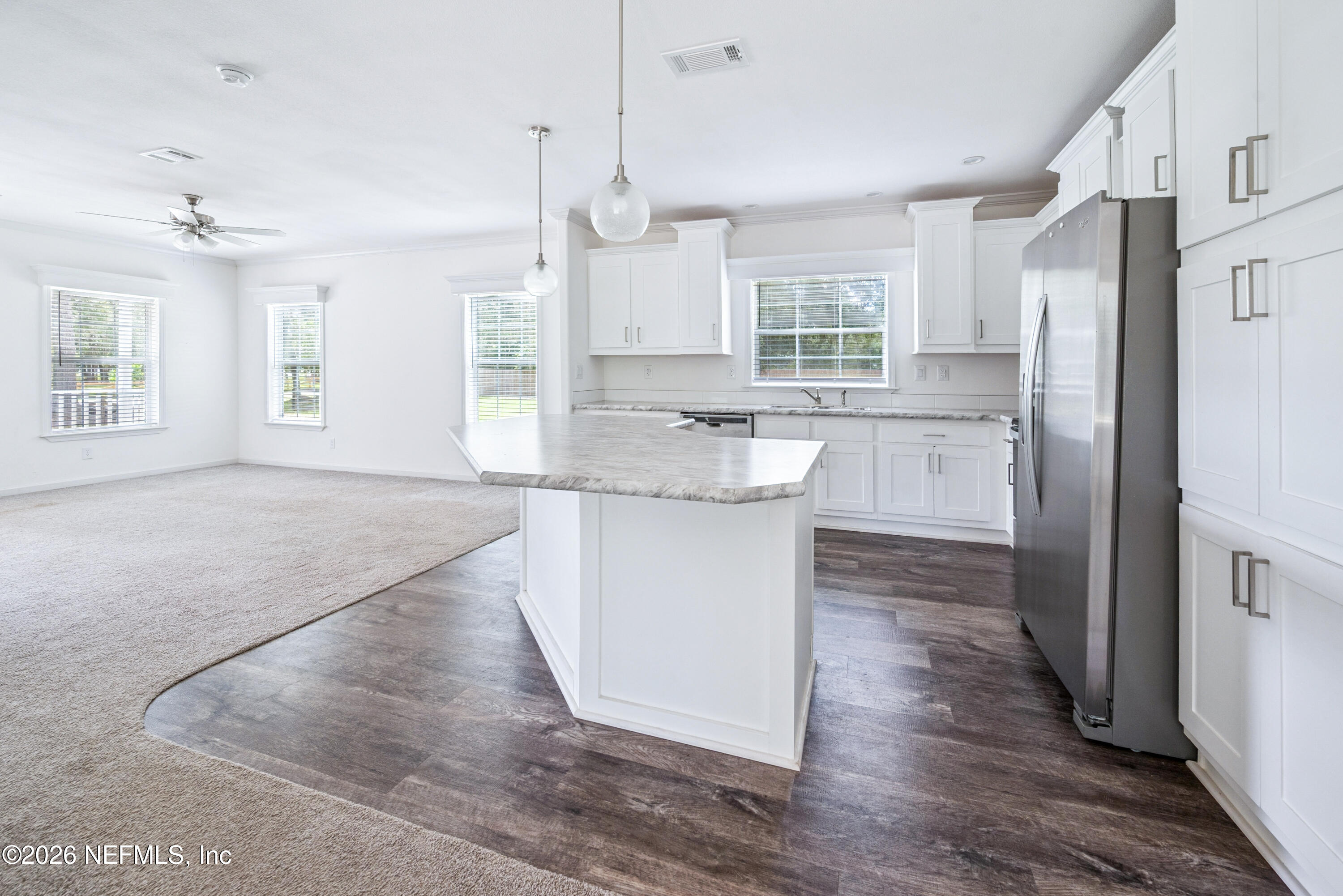 15049 Southwest 75th Avenue Starke, FL 32091 - Photo 44 of 64 a kitchen with stainless steel appliances granite countertop a refrigerator a sink dishwasher a stove and white cabinets with wooden floor