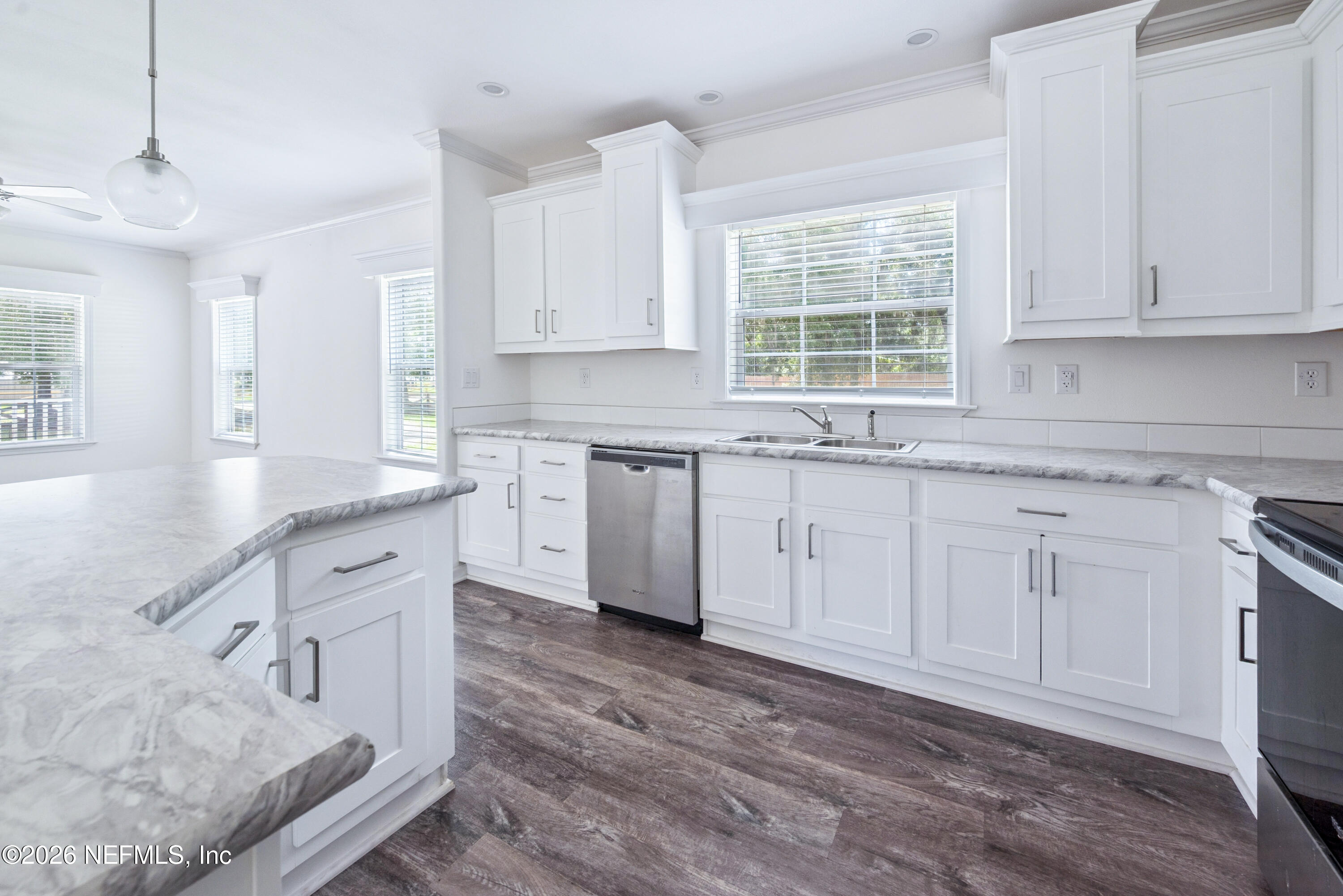 15049 Southwest 75th Avenue Starke, FL 32091 - Photo 46 of 64 a kitchen with granite countertop white cabinets white appliances a sink and a window