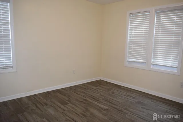 an empty room with wooden floor and a window