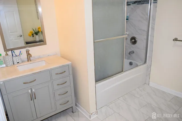 a bathroom with a double vanity sink a mirror and a bathtub