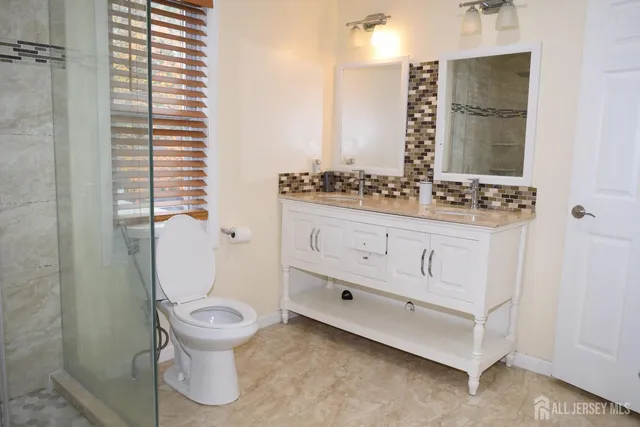 a bathroom with a granite countertop toilet sink and mirror