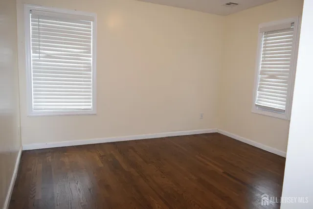 an empty room with wooden floor and a window