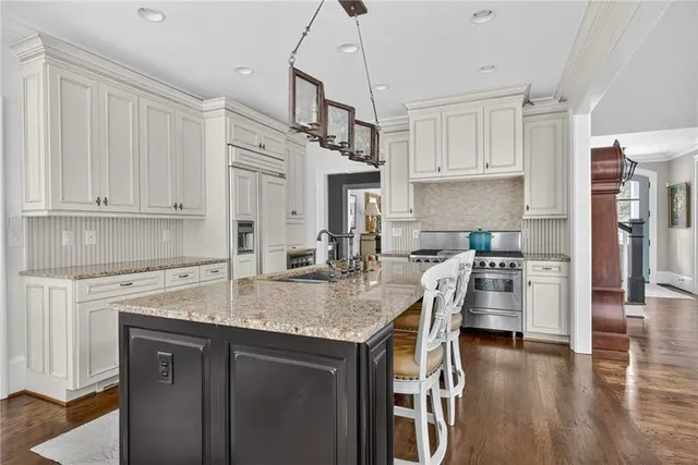 a kitchen with stainless steel appliances granite countertop a sink a stove and a refrigerator