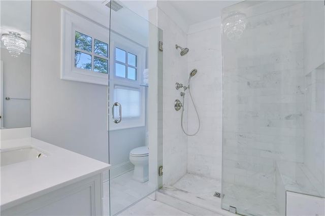a bathroom with a sink a toilet and a large mirror