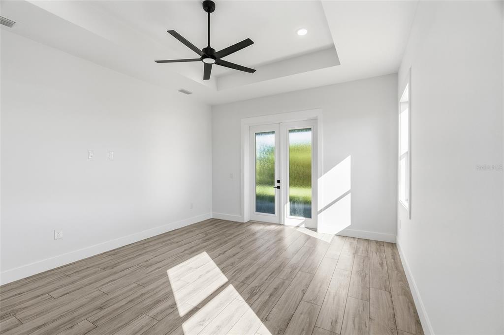 210 Tournament Road Rotonda West, FL 33947 - Photo 14 of 59 a view of an empty room with a window and wooden floor