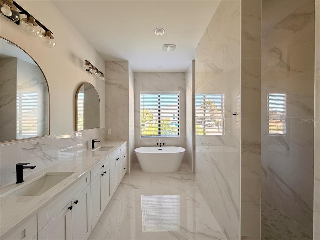 210 Tournament Road Rotonda West, FL 33947 - Photo 17 of 59 a spacious bathroom with a double vanity sink mirror and bathtub