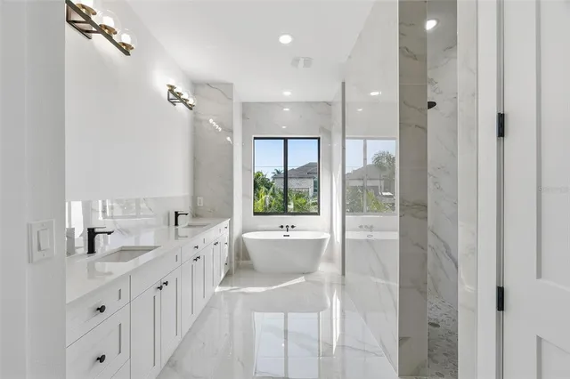 a bathroom with a double vanity sink large mirror and a bathtub