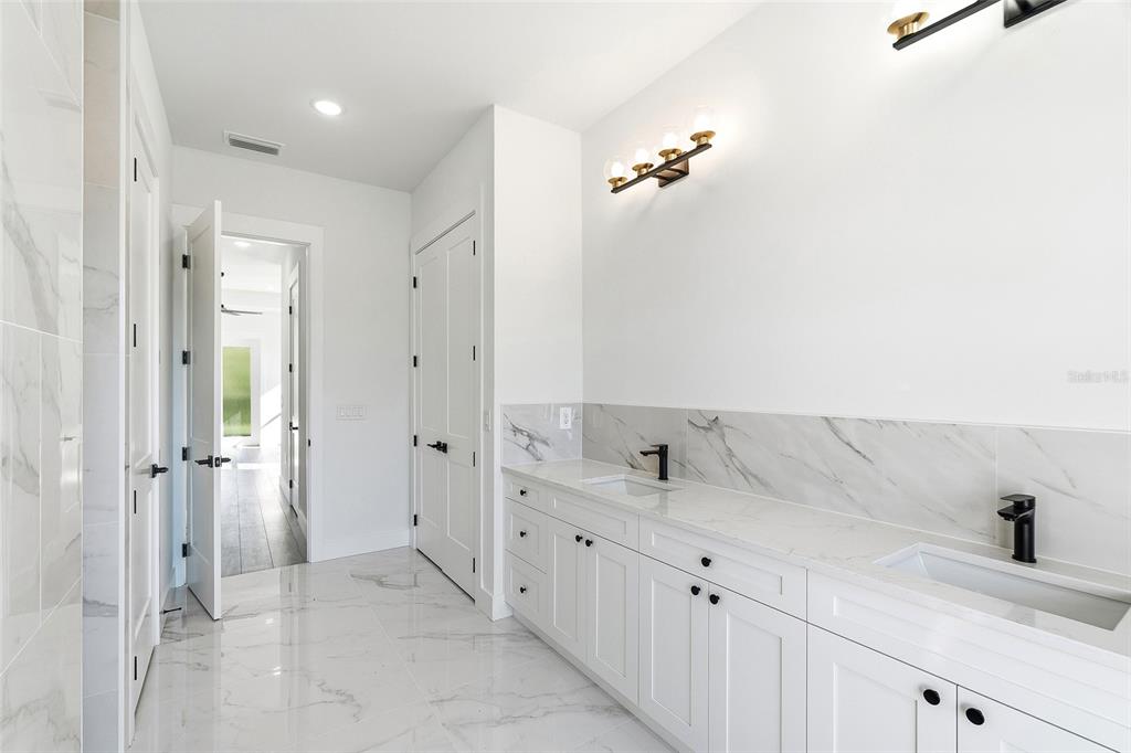 210 Tournament Road Rotonda West, FL 33947 - Photo 20 of 59 a bathroom with a double vanity sink and mirror
