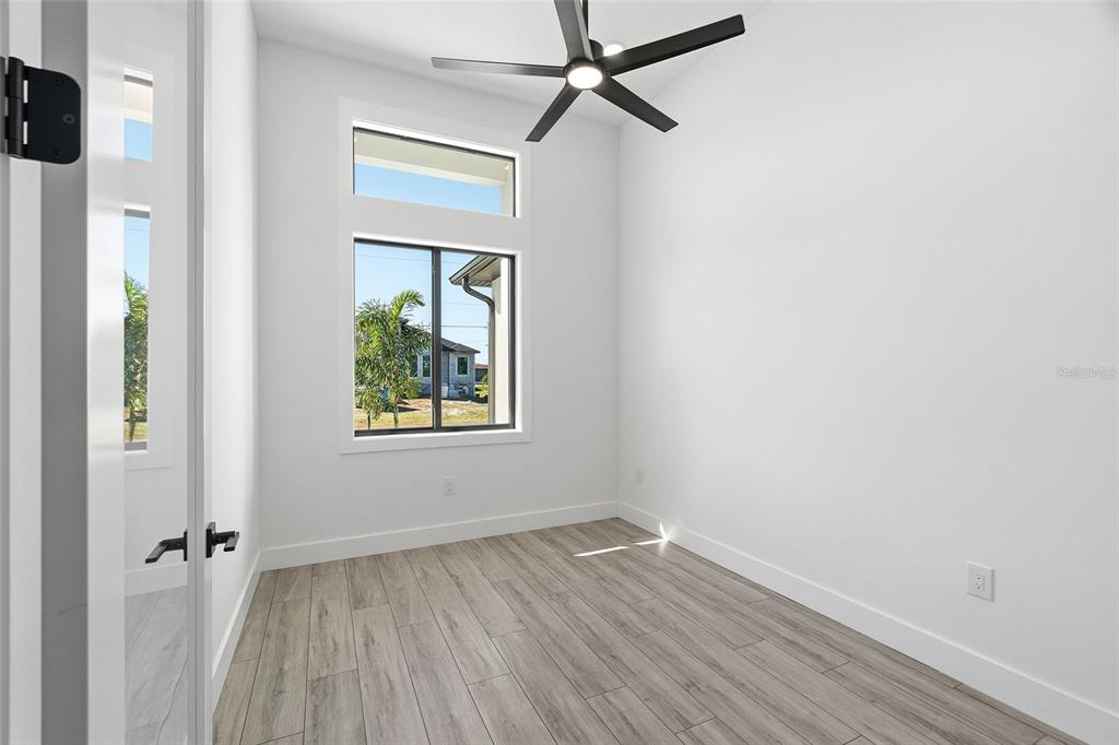 210 Tournament Road Rotonda West, FL 33947 - Photo 26 of 59 a view of an empty room with a window and wooden floor