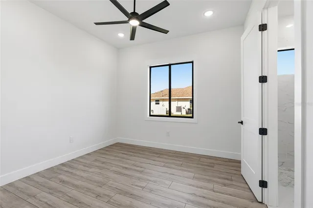 an empty room with wooden floor and natural light
