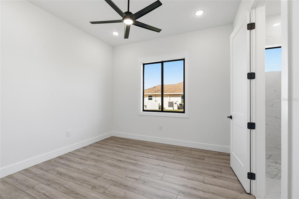 210 Tournament Road Rotonda West, FL 33947 - Photo 31 of 59 an empty room with wooden floor closet and windows