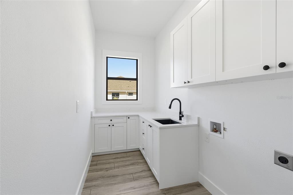 210 Tournament Road Rotonda West, FL 33947 - Photo 42 of 59 a kitchen with sink cabinets and wooden floor