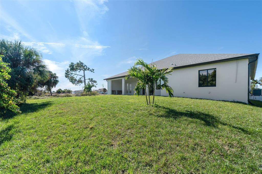 210 Tournament Road Rotonda West, FL 33947 - Photo 48 of 59 a view of a house with a yard and palm trees
