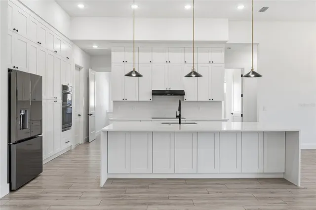 a view of a kitchen with stainless steel appliances granite countertop cabinets and wooden floor