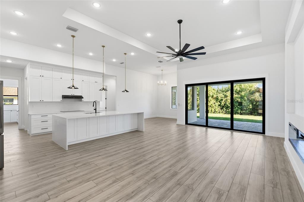 210 Tournament Road Rotonda West, FL 33947 - Photo 8 of 59 a large kitchen with stainless steel appliances granite countertop a stove a refrigerator a sink and a large window with wooden floor