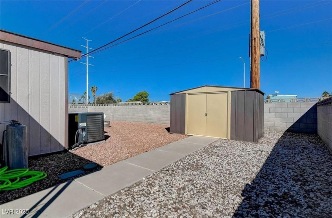 5576 Aldama Road Las Vegas, NV 89122 - Photo 20 of 23 Fenced backyard featuring a storage shed