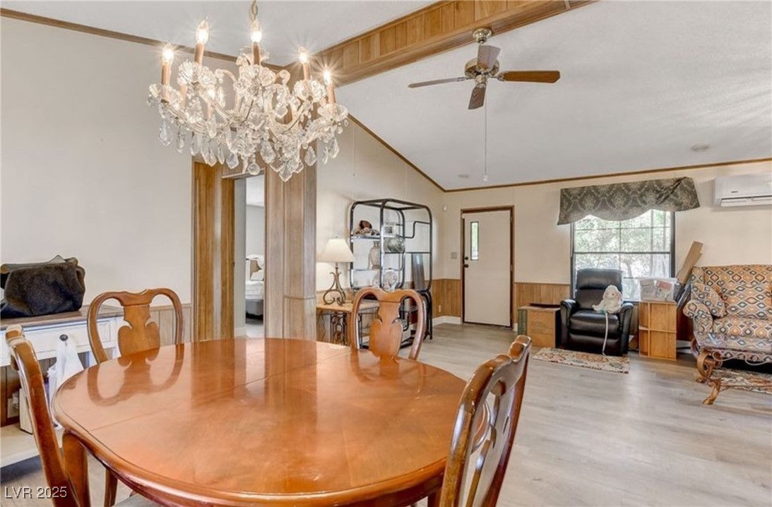 5576 Aldama Road Las Vegas, NV 89122 - Photo 10 of 23 Dining area featuring lofted ceiling, wainscoting, wood finished floors, ceiling fan, and a wall mounted air conditioner