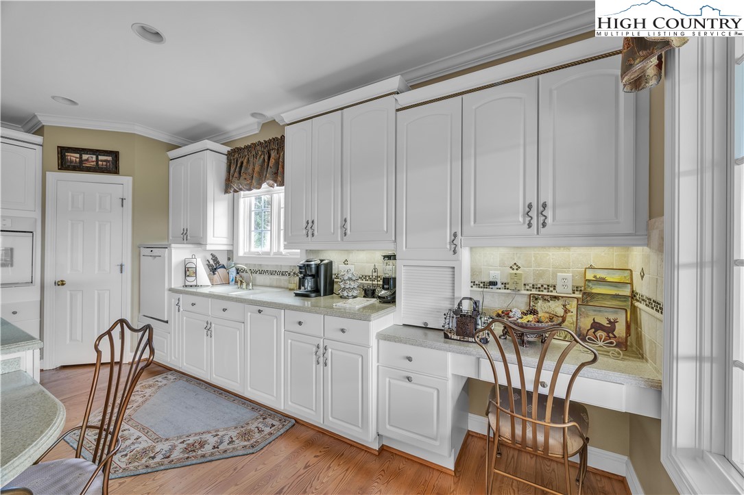 891 Olde Charter Circle Jefferson, NC 28640 - Photo 11 of 49 a kitchen with stainless steel appliances granite countertop a stove top oven a sink a dining table and chairs with wooden floor