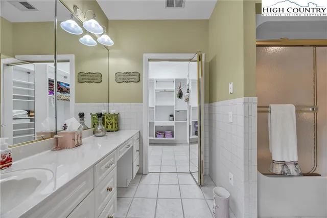 a spacious bathroom with a granite countertop sink mirror and a shower