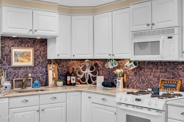 a kitchen with white cabinets and white appliances